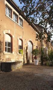 a building with a large door and a courtyard at Matin de Saône in Fontaines-Saint-Martin