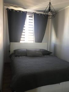 um quarto com uma cama e uma janela com cortinas em ApartamentLeśna12Hel em Hel