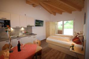 eine Küche mit einem Bett und einem Tisch in einem Zimmer in der Unterkunft Ferienwohnungen Karwendel Camping in Maurach