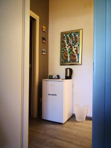 einen weißen Kühlschrank in einem Zimmer mit einem Bild an der Wand in der Unterkunft Casa Di Amici in Caltanissetta