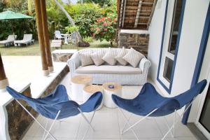 a living room with a couch and two blue chairs at Blue Bird in Pereybere