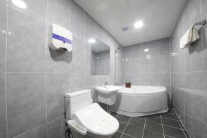 La salle de bains est pourvue de toilettes blanches et d'un lavabo. dans l'établissement Eco Hotel, à Mokpo
