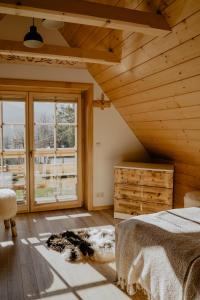 a bedroom with a bed and a large window at Biolo i Corno Izba Mountain Chalets in Kościelisko