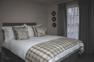 a bedroom with a bed with white sheets and a window at The Angel Inn in Wangford