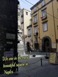 een stadsstraat met gebouwen en een bord dat zegt dat we op het mooiste plein bij Ad un passo dal Duomo "2" in Napels