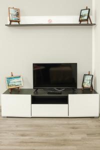 ein weißes Entertainment-Center mit einem Flachbild-TV in der Unterkunft Apartmani Bojana in Vrdnik