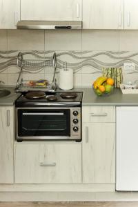 a kitchen with a stove and a bowl of fruit at Apartmani Bojana in Vrdnik