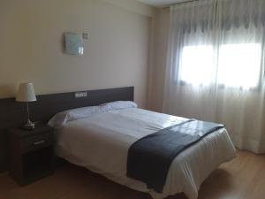 Un dormitorio con una cama grande y una ventana en Hotel Casa Marzo, en Cariñena