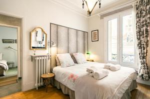 een slaapkamer met een bed met handdoeken erop bij Maison Chanzy in Parijs