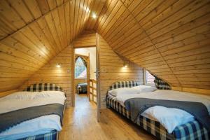 pokój z 2 łóżkami w drewnianym domku w obiekcie Mała Osada domki z jacuzzi przy gondoli w Szczyrku