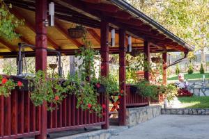 a wooden pergola with potted plants on it at Apartmani Bojana in Vrdnik