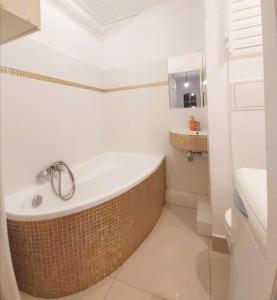 La salle de bains est pourvue d'une baignoire et d'un lavabo. dans l'établissement Dworcowa przy basenie, à Olsztyn