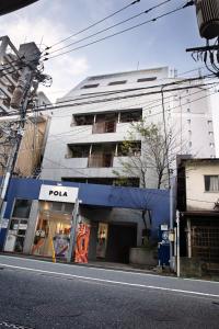 een poda winkel in een stadsstraat met een gebouw bij Cocone house Ohoripark in Fukuoka