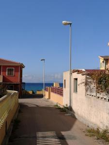 uma rua vazia com o oceano ao fundo em Apartamento 70 Metri della spiaggia em Castelsardo
