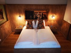 Schlafzimmer mit einem Bett mit weißer Bettwäsche und Kissen in der Unterkunft Gasthof Stauder in Innsbruck