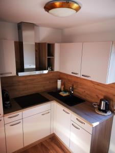 una cocina con armarios blancos y fregadero en Stauders Zimmer und Ferienwohnungen en Innsbruck