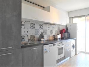La cuisine est équipée d'un évier et d'un lave-vaisselle. dans l'établissement Appartement Le Jean Bart - Vacances Côte d'Azur, à Mandelieu-la-Napoule