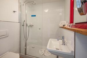 a bathroom with a shower, sink, and toilet at Strandhotel Heringsdorf in Heringsdorf