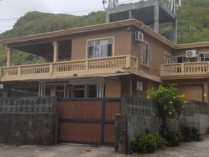 a large house with a wooden gate and a fence at JN sunflower residence in Le Morne
