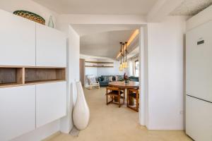 a kitchen and dining room with white cabinets and a table at Villa Taguluche Famara in Famara