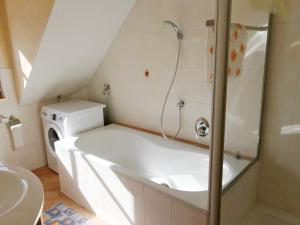 a bathroom with a bath tub and a sink at Ferienwohnung Burgblick in Betzenstein