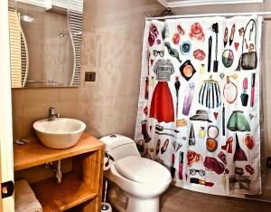 a bathroom with a toilet and a shower curtain with shoes at Mirabosque New Apartments 3 in Osorno
