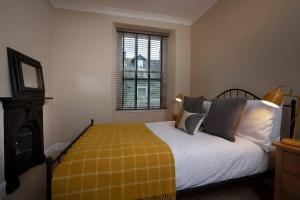 a bedroom with a bed with a yellow blanket at Fairmead in Ambleside