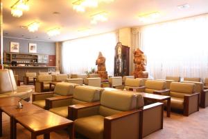 a waiting room with chairs and tables and a large window at Hotel Towadaso in Towada