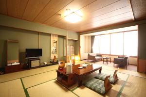 a living room with a couch and a table at Hotel Towadaso in Towada