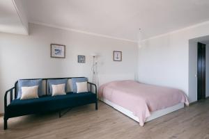 een slaapkamer met een bed en een blauwe bank bij BINIS Apartment in Funchal
