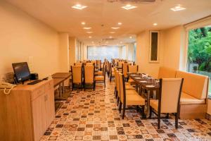 una sala da pranzo con tavoli, sedie e TV di Hotel Regent Laguna ad Anjuna