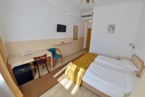 a bedroom with a bed and a desk and a table at Hotel Gallant in Sibiu