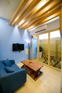 ein Wohnzimmer mit einem blauen Sofa und einem Tisch in der Unterkunft 夏海民宿 in Magong