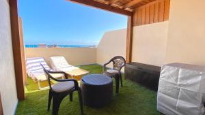a balcony with chairs and a table and a heater at Red Surf Home in Corralejo
