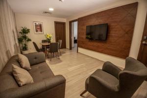 a living room with two couches and a television on a wall at Lacosta Hotel in Aqaba