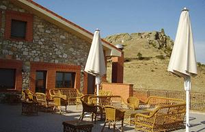 a group of tables and chairs with white umbrellas at La Becera in Peñausende