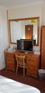 1 dormitorio con escritorio, TV y espejo en Milka's, en Oxford