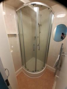 a shower with a glass door in a bathroom at The Edenhurst Guesthouse in Weymouth