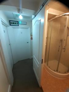 a bathroom with a shower and a glass door at The Edenhurst Guesthouse in Weymouth