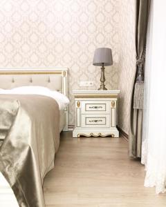 um quarto com uma cama e uma mesa com um candeeiro em Dolce Vita Apartments em Mariánské Lázně