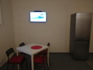 a room with a white table and a refrigerator at Hotel - penzion M&M in Jáchymov