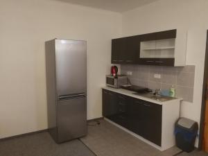 a kitchen with a stainless steel refrigerator and a sink at Hotel - penzion M&M in Jáchymov