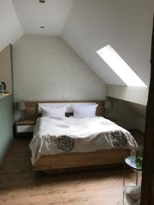 Schlafzimmer mit einem großen Bett und einem Dachfenster in der Unterkunft Historische Mühle Vogelsang in Brodenbach