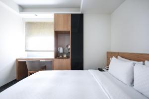 Rúm í herbergi á Dandy Hotel-Daan Park Branch