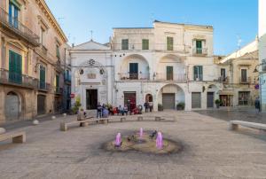 a group of buildings in a street with a fountain at Da noi. Nella città dell'acqua e della pietra. in Gravina in Puglia