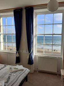 a bedroom with a bed and a view of the beach at The Edenhurst Guesthouse in Weymouth