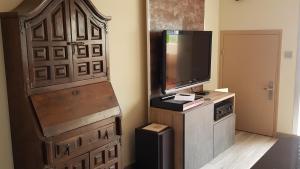 een kamer met een grote houten deur en een televisie bij Le Sud sur Plage in Mèze