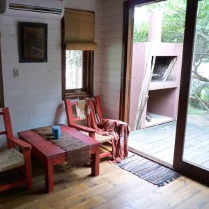 a living room with a table and chairs and a porch at Las Casquivanas in Punta Del Diablo