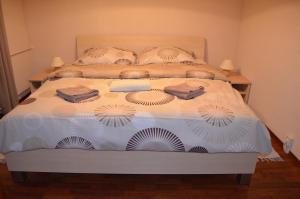 een slaapkamer met een groot bed met witte lakens en ventilatoren bij Apartmán Leny in Tatranská Lomnica