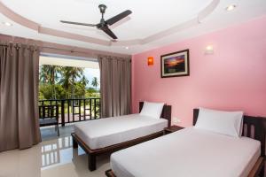 2 letti in una camera con balcone di Baan Suan Ta Hotel a Ko Tao